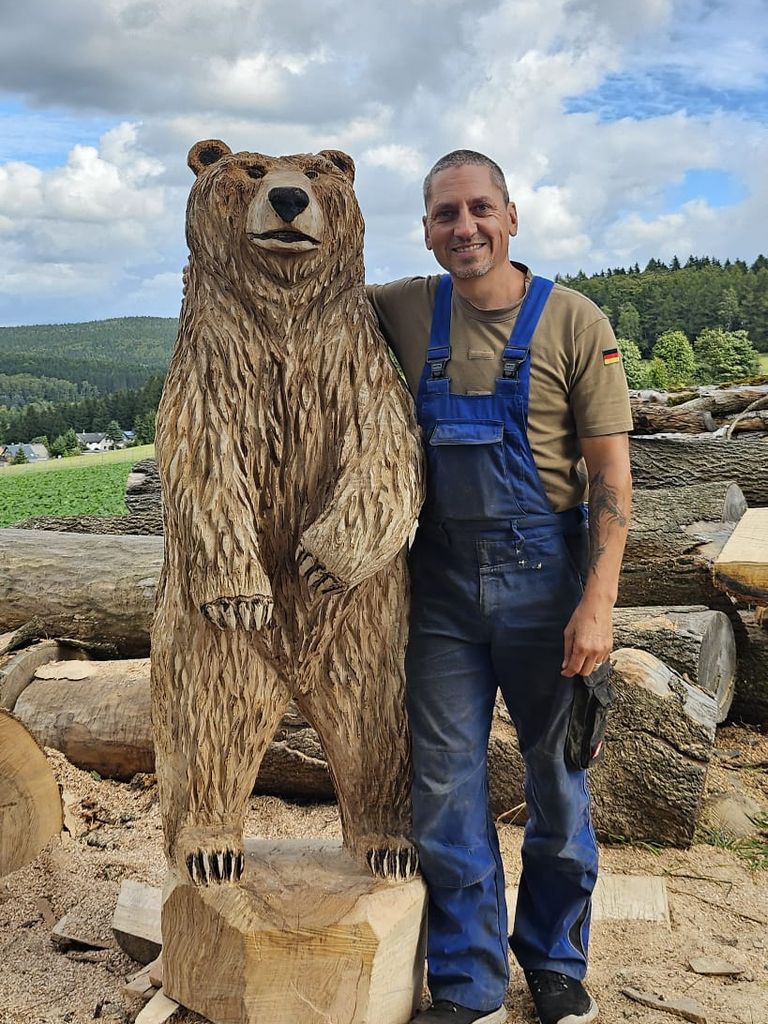Kettensägenkünstler Andreas Patzak neben lebensgroßer Holzbär-Skulptur aus Massivholz – Auftragsarbeit, Erzgebirge Sachsen